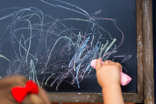 Chalk scribbles of young child drawing on blackboard