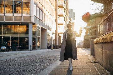 middle-aged happy woman with a heart-shaped balloon falling a love, having a fun day, walking...