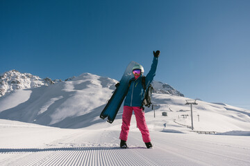 Female snowboarder walking on Snow trail from ratrak preparation, freshly groomed ski slope in high...