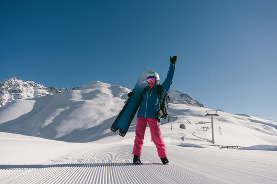 Female snowboarder walking on Snow trail from ratrak preparation, freshly groomed ski slope in high mountains ski resort