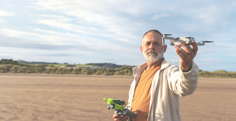 An old man launching a drone at the seashore to take video and photos of the sea