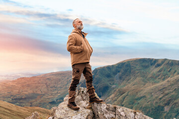 Bearded Man reaching the destination  and on the top of mountain  at sunset on autumn day  Travel  Lifestyle concept The national park Lake District in England - obrazy, fototapety, plakaty