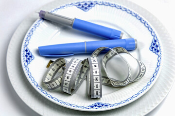Ozempic Insulin injection pen or insulin cartridge pen for diabetics on a white plate.