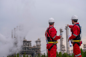 Engineer survey team wear uniform and helmet stand workplace checking blueprint project , radio...