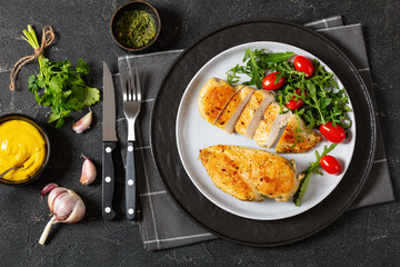 fried chicken breasts with green salad on plate