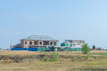 Fototapeta premium Beachside Hilltop Retreat with Countryside Charm Under the Blue Sky A Summer Getaway in Cambodia Serene Landscape with Houses Nestled Among Trees, Fields, and the Shoreline