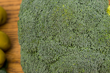 broccoli and olives on the wooden table, close-up