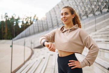A woman does sports on the street. Fitness and a healthy lifestyle. The trainer does exercises for stretching the body. Sport, Active life, sports training, healthy lifestyle.