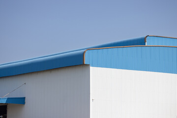 white and blue metal factory with blue sky background. large metal cargo.