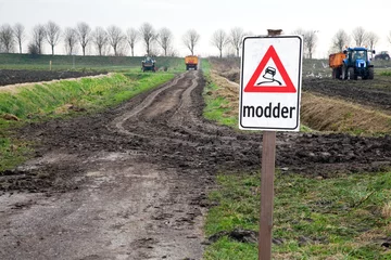 Foto auf Alu-Dibond Verkeersbord met waarschuwing tijdens het oogsten in de agrarische sector. Door de modder wat door de tractor op de weg gegooid wordt is deze gevaarlijk voor het verkeer © ArieStormFotografie