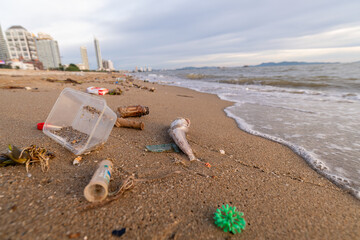 Fototapeta na wymiar Spilled garbage on beach is dirty plastic bottles it make dirty sea sandy shore environmental pollution. is ecological problem concept.