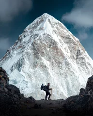 A mountaineer with a backpack observes the great mountain of Pumori while making the ascent to Everest Base Camp in the Himalayas Nepal