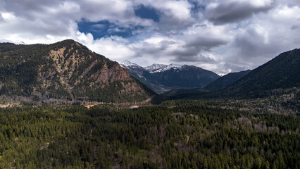 Beautiful mountain landscape. Clouds in the sky. Green grass. Snow on mountain peaks.