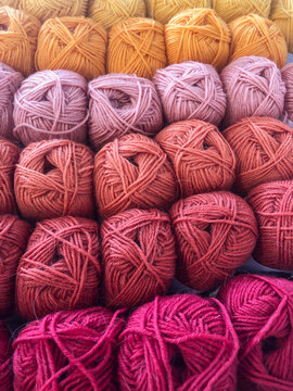 Sets of colourful skein yarn lined up in rows.
