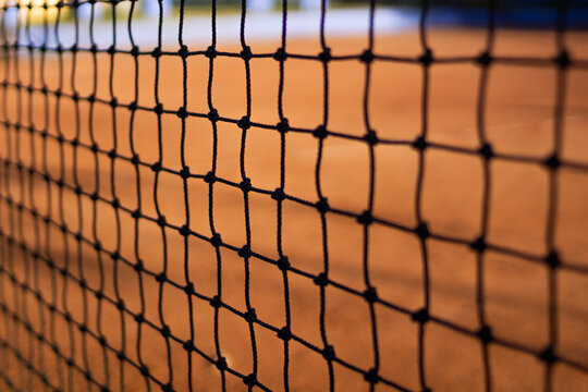 Net and clay tennis court background. With blur on the sides