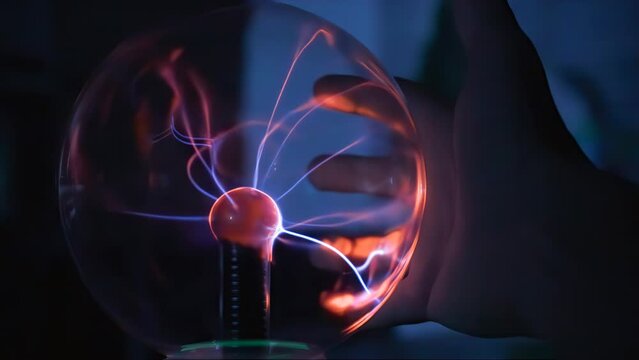 Hand of scientist touching a plasma ball.