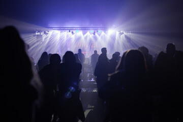 Silhouette of people at an music event indoors