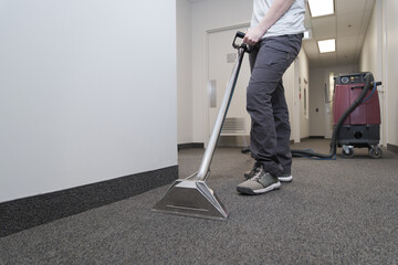 female worker cleaning a carpet, closeup of pressure jets