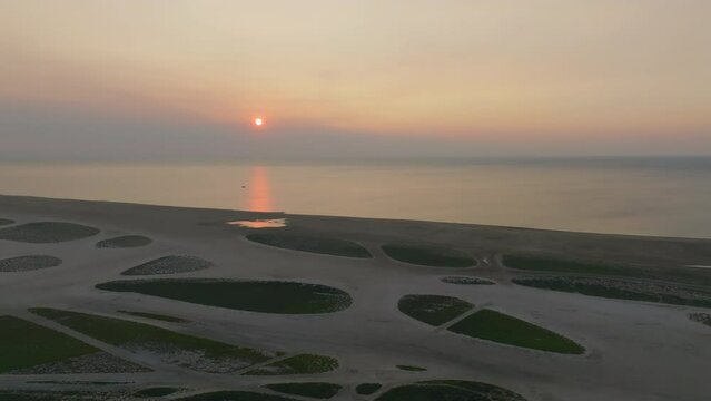 A tranquil sunset casting a warm glow over a serene coastal wetland landscape, with intricate patterns of tidal pools reflecting the last light of day