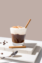 Café irlandés con crema batida y canela sobre mármol en un fondo beige	