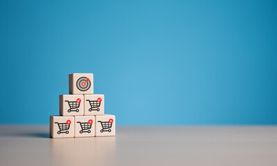 Business target dartboard and shopping cart icon on wooden cubes. Increase sale volume for higher...