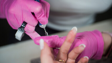 Obraz na płótnie Canvas a girl gets a manicure in a beauty salon