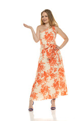 Naklejka premium Full body front view portrait of elegant lovely blond lady holding imaginary product isolated on white background in floral long dress
