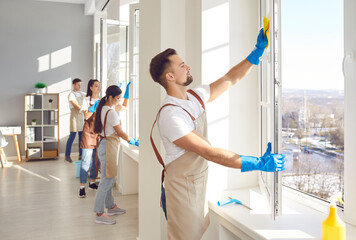 Male cleaner and group window washing, working, professional janitor service busy completing...