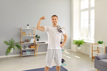 Portrait of happy sportsman after fitness workout at home. Handsome, fit, sporty man in white T...