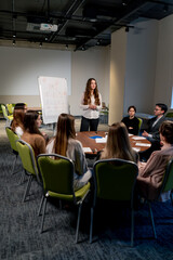 business conference or meeting at the hotel the girl on the flipchart shows the development plan...
