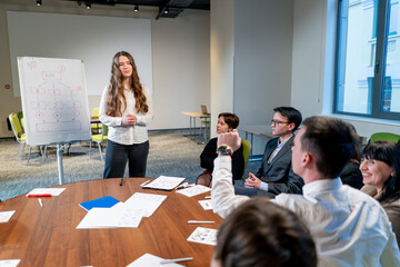 business conference or meeting at the hotel the girl on the flipchart shows the development plan for the company