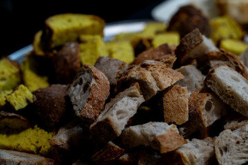 still life of pieces of different types of bread with sourdough and whole wheat flour on a black background