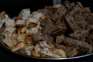 still life of pieces of different types of bread with sourdough on a black background