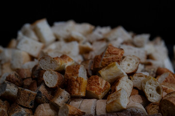 still life of pieces of different types of bread on a black background