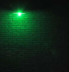 green chandelier lamp in a black brick room
