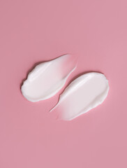 Cosmetic smear, cream texture on a pink background. Skin care.