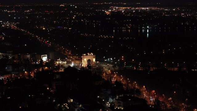 Night Aerial View of Roundabout or Arch de Triumph in Bucharest City. Aerial view of triumphal arch in Bucharest Romania. Aerial night shot of traffic on the main boulevard. City lights by night.