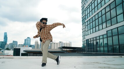 Happy hispanic dancer wears casual outfit break dancing at urban city. Energetic hip-hop...