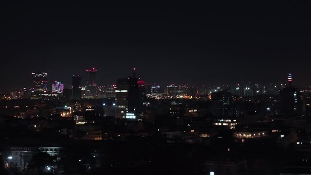 Fly over night shot in urban area. Night Aerial View over Bucharest. Cityscape view over city. Bucharest at night. City Skyline In Romania. Business Skyscraper buildings. Film grain texture.