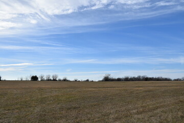 Obraz premium Clouds in a Blue Sky Over a Field