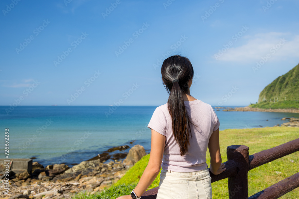 Wall mural Woman look at the sea beach