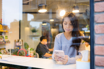 Woman use of mobile phone in coffee shop