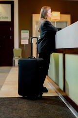 Young businesswoman arrived at the hotel with a suitcase Travel concept