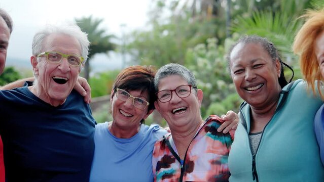 Multiracial senior friends having fun after exercise or yoga workout at Park City. Elderly healthy life style