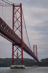 Alcântara, Lisbon PORTUGAL - May 29, 2022 - Perspective of the 25th April bridge over the Tejo river framing the silhouette of Christ the King on the other bank
