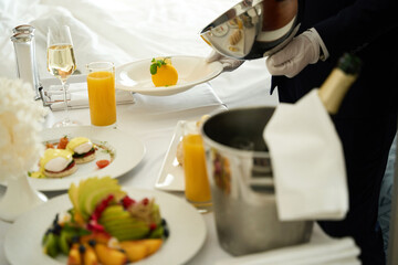 Waiter serves breakfast in the room