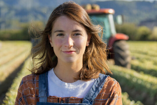 jeune agricultrice devant un tracteur
