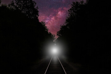 Train and train light on track at night milky way sky