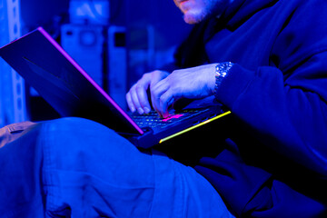 close-up of hands of hacker pressing keys on keyboard in data center vulnerable cyber security...