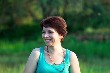 happy mid age woman with red hair having fun in the park